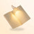 Lampe blanche mini clip light éclairant un livre tenu à deux mains dans la pénombre