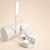 Lampe flexible blanche posée sur un cylindre blanc, doigt appuyant sur le bouton variateur trois vitesses