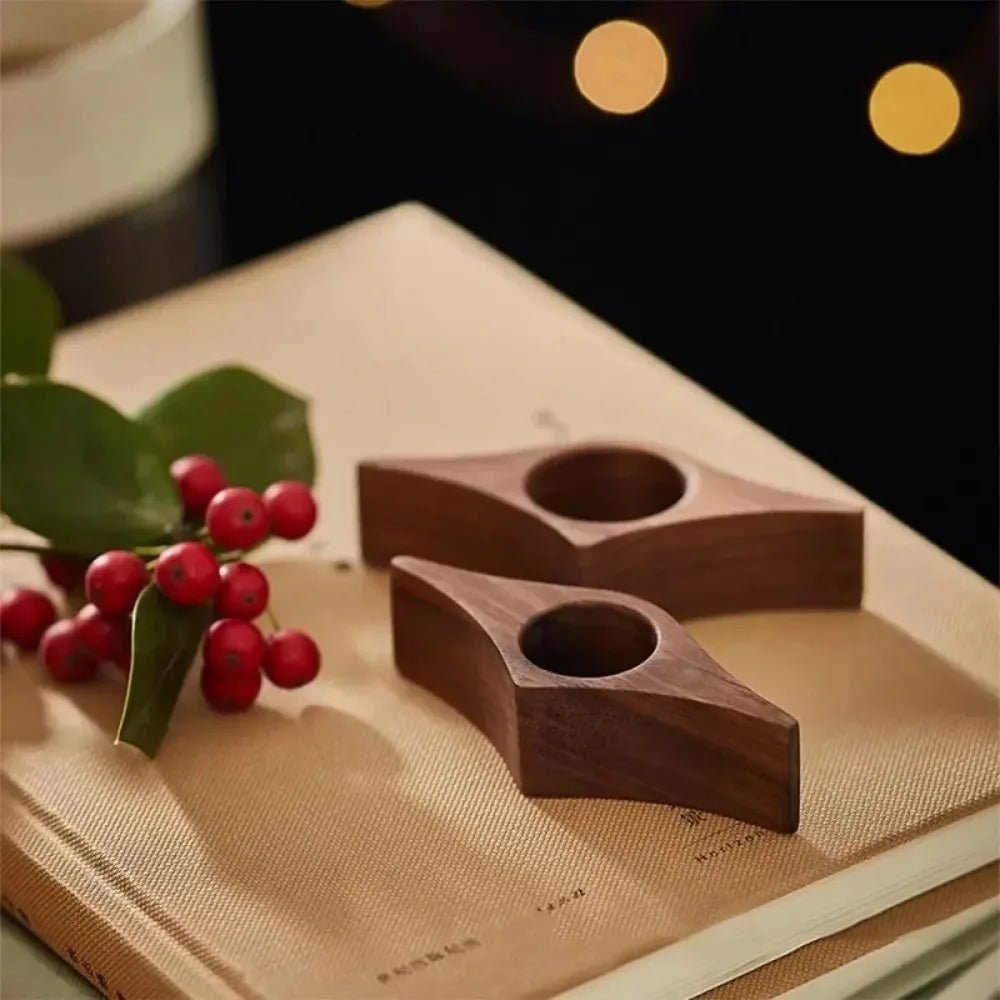 Deux accessoires de lecture en bois foncé posés sur des livres près de baies rouges