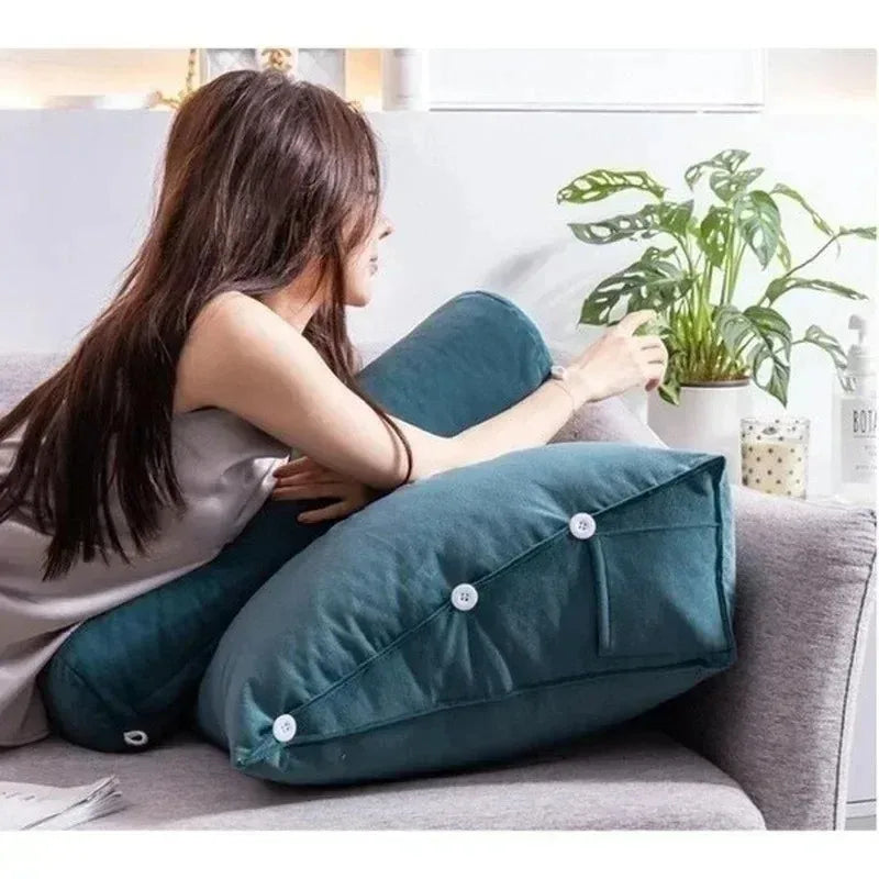 Femme assise sur un canapé avec deux coussins triangulaires