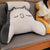 coussin de lecture gris et blanc avec motif chat sur un canapé