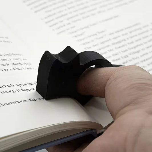 Pouce glissé dans l’ouverture d’un porte-page noir pour maintenir un livre ouvert