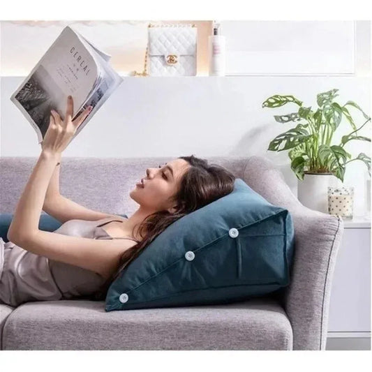 Femme lisant avec un coussin triangulaire derrière le dos