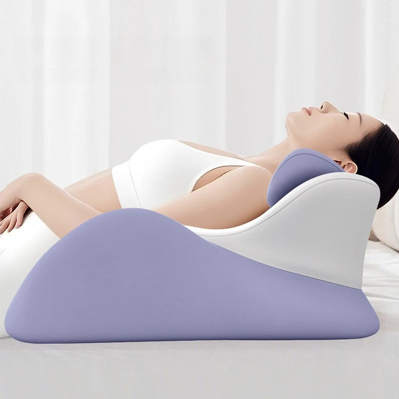 Femme assise contre un coussin violet et blanc en train d’utiliser son téléphone