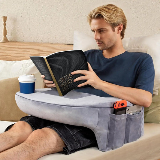homme lisant un livre posé sur un coussin repose livre gris avec poches de rangement