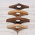 Quatre supports de pages en bois de teintes variées disposés sur un livre ouvert