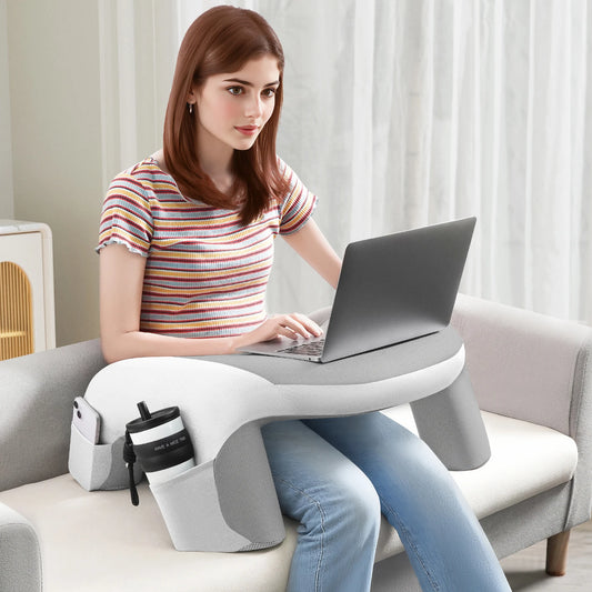 femme assise sur un canapé utilisant un coussin de lecture pour poser son ordinateur portable