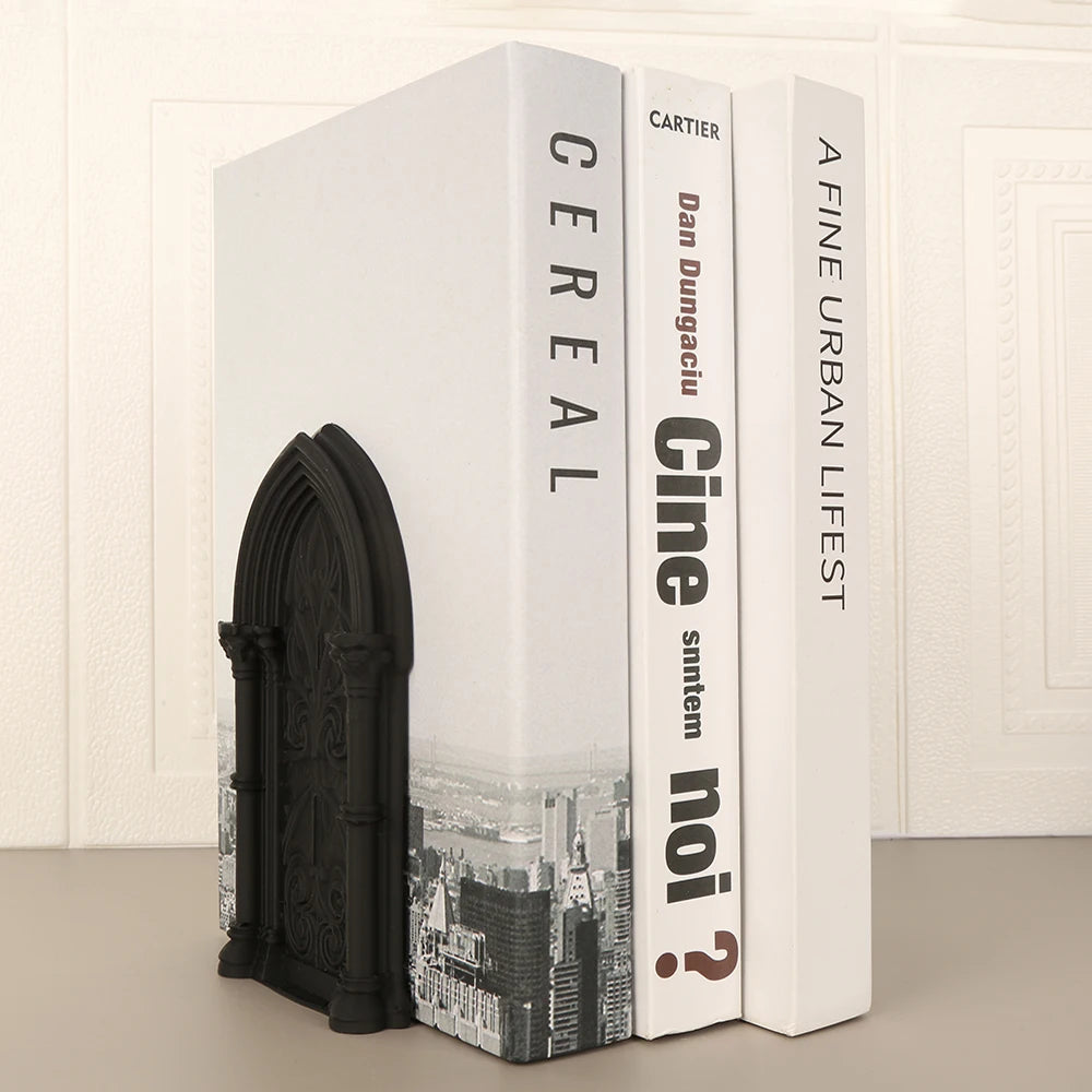 Serre-livres noir en forme d'arche placé contre trois ouvrages