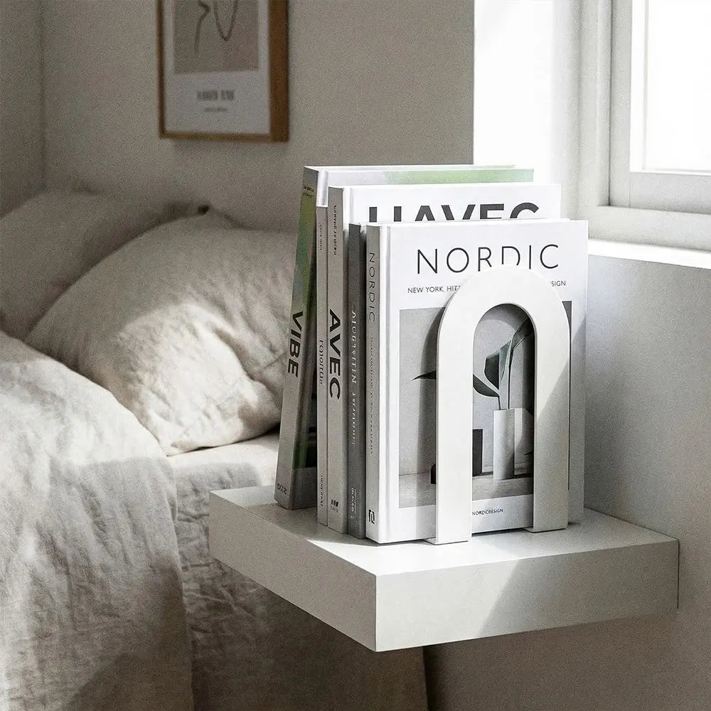 Support blanc maintenant des livres sur une table de chevet