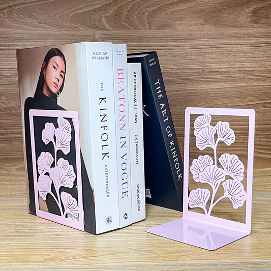Deux supports floraux roses disposés de chaque côté d'une rangée de livres
