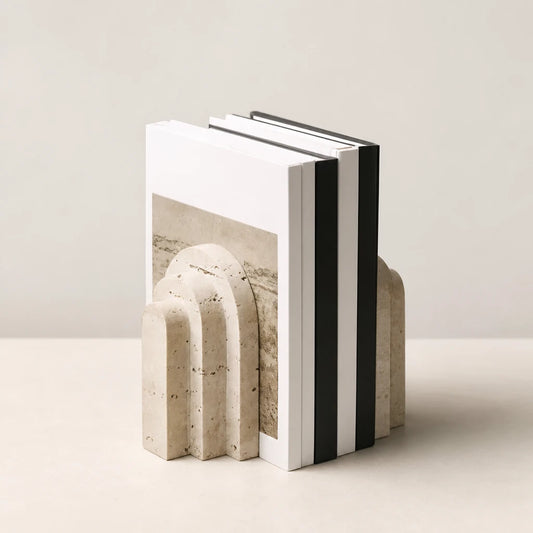 Serre-livres en marbre en forme d'arche sur un bureau blanc, maintenant plusieurs livres dont un Van Gogh