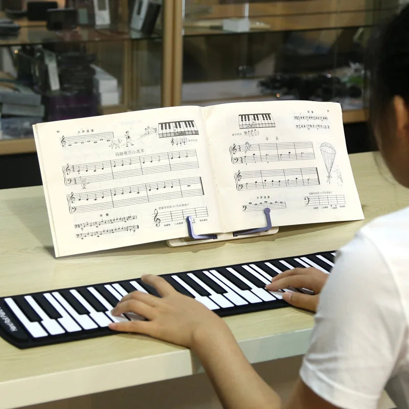 Partition ouverte sur un pupitre devant un clavier musical