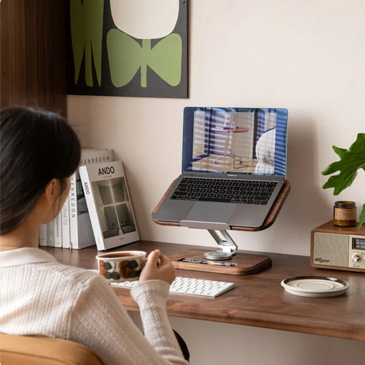 Ordinateur portable posé sur le support réglable face à une utilisatrice